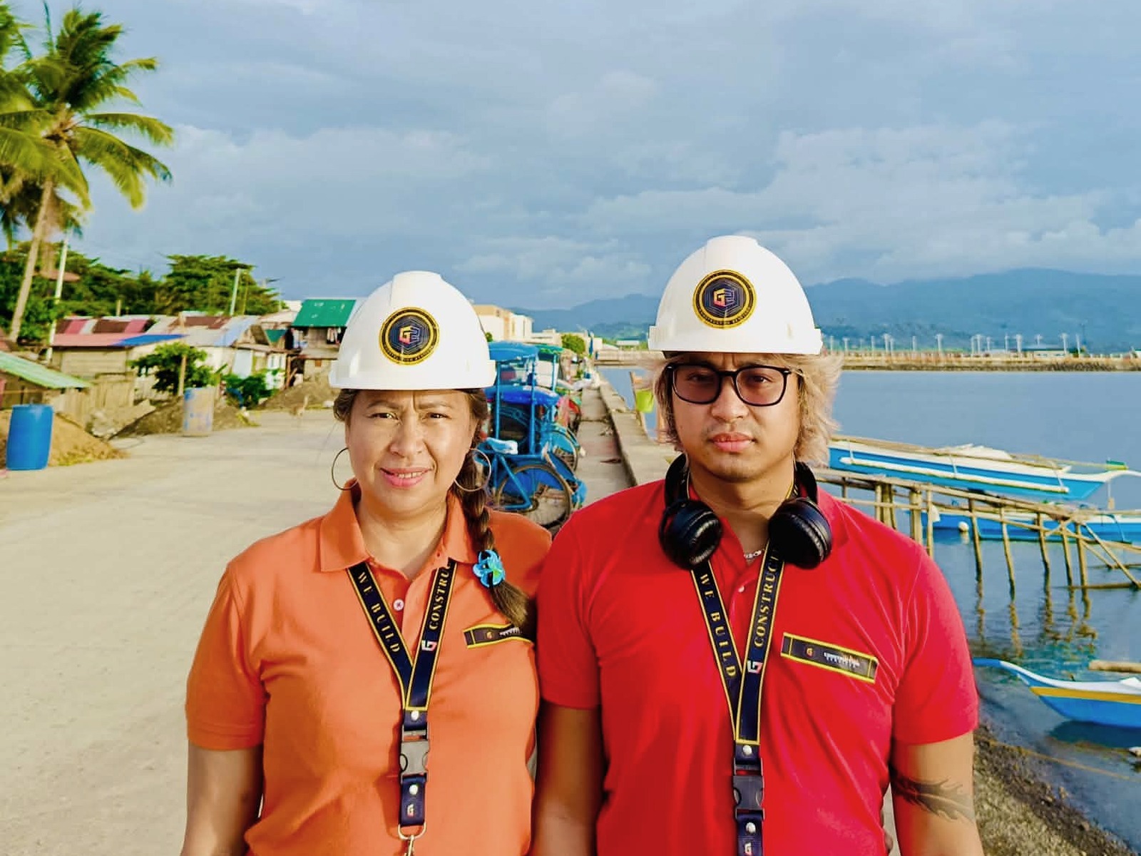 Two G2 representatives wearing branded safety helmets during a field visit