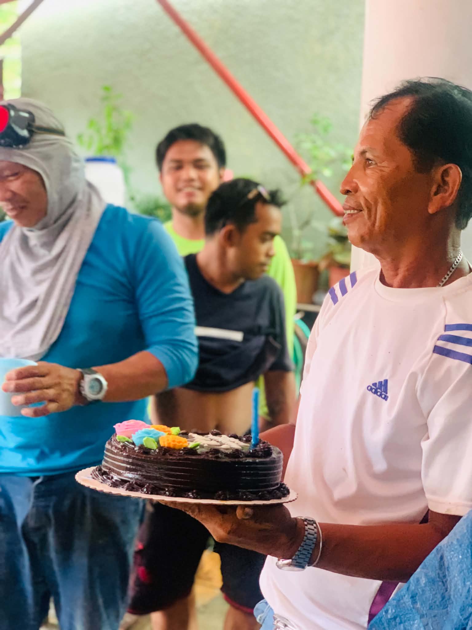 A G2 team member holding a birthday cake during a team celebration